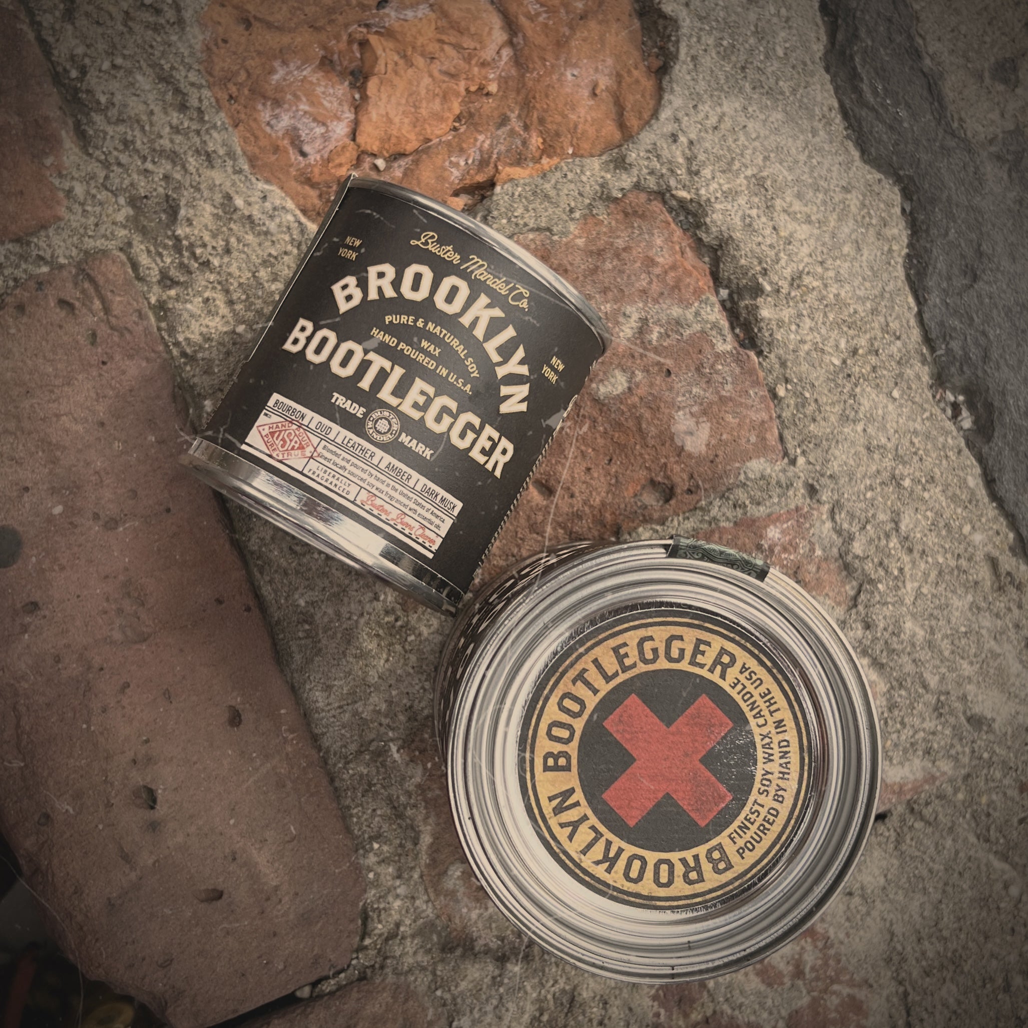 Manly Brooklyn Bootlegger with vintage apothecary candle style tin and rugged packaging. Features bourbon, oud, leather, and amber notes. Hand-poured in the USA