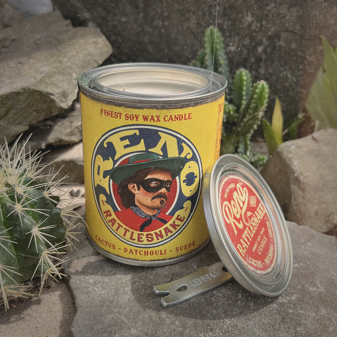 Buster Mandel Reno Rattlesnake Candle in a rugged outdoor setting with cactus, evoking a bold, Western-inspired masculine fragrance. Sandalwood, patchouli & suede. Mancave idea