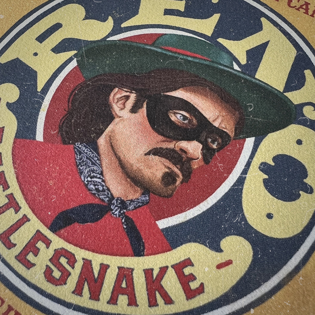 Vintage Western cowboy illustration on the Reno Rattlesnake Candle label by Buster Mandel. Rugged Americana design for a bold, masculine candle brand