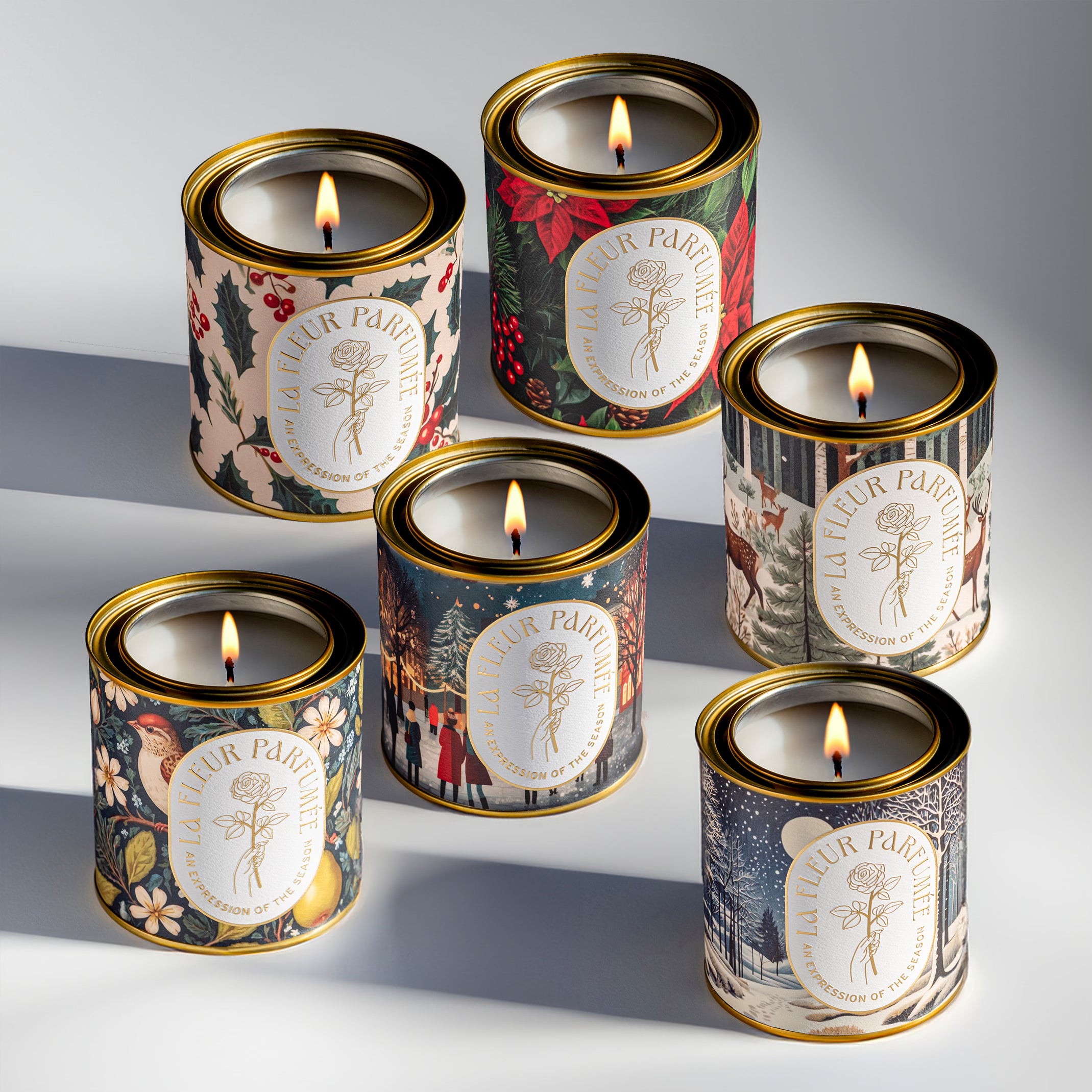 A collection of 6 festive holiday candles with bold colorful winter themed artwork