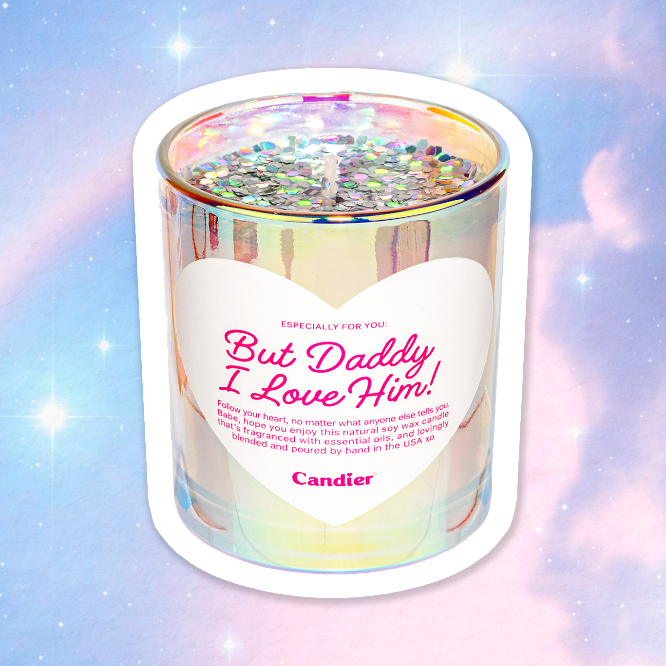 A shiny metallic scented candle with sparkling plant based glitter, and a heart shaped label that reads But Daddy, I Love Him by Candier® with a cosmic background