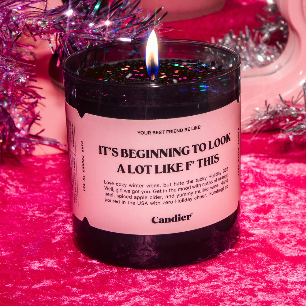 A luxury Christmas candle with a pink label that reads It's beginning to look a lot like F this"