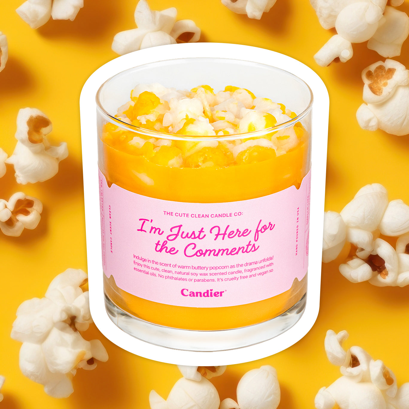 A fun premium scented candle topped with realistic wax popcorn and a label that reads I'm Just Here For The Comments, by Candier®, with a background full of popcorn