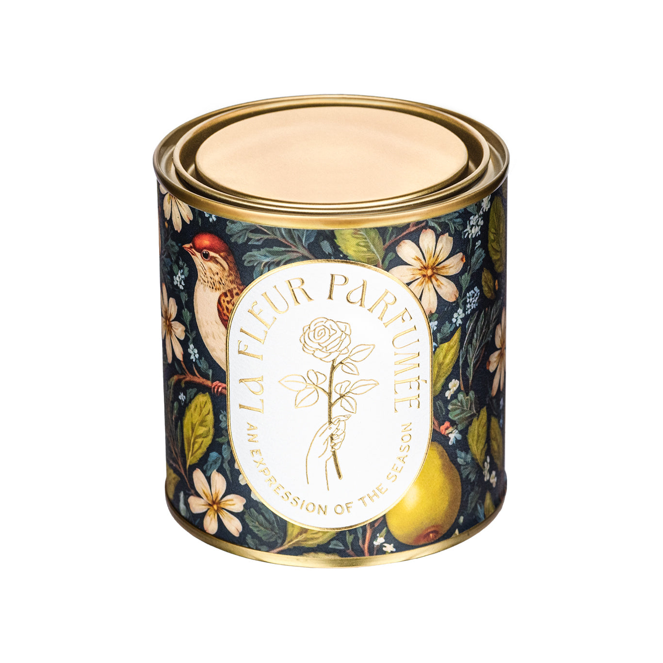 An elegant luxe lit gold-tone candle,  wrapped in artwork of a serene winter woodland scene featuring majestic white-tailed deer congregating on snow-covered terrain, framed by tall evergreens. The soft, neutral tones of the trees complement the snow-covered earth, evoking a calm atmosphere. The composition captures a tranquil winter day, with the wildlife enhancing the sense of natural beauty amidst the crisp, cool landscape