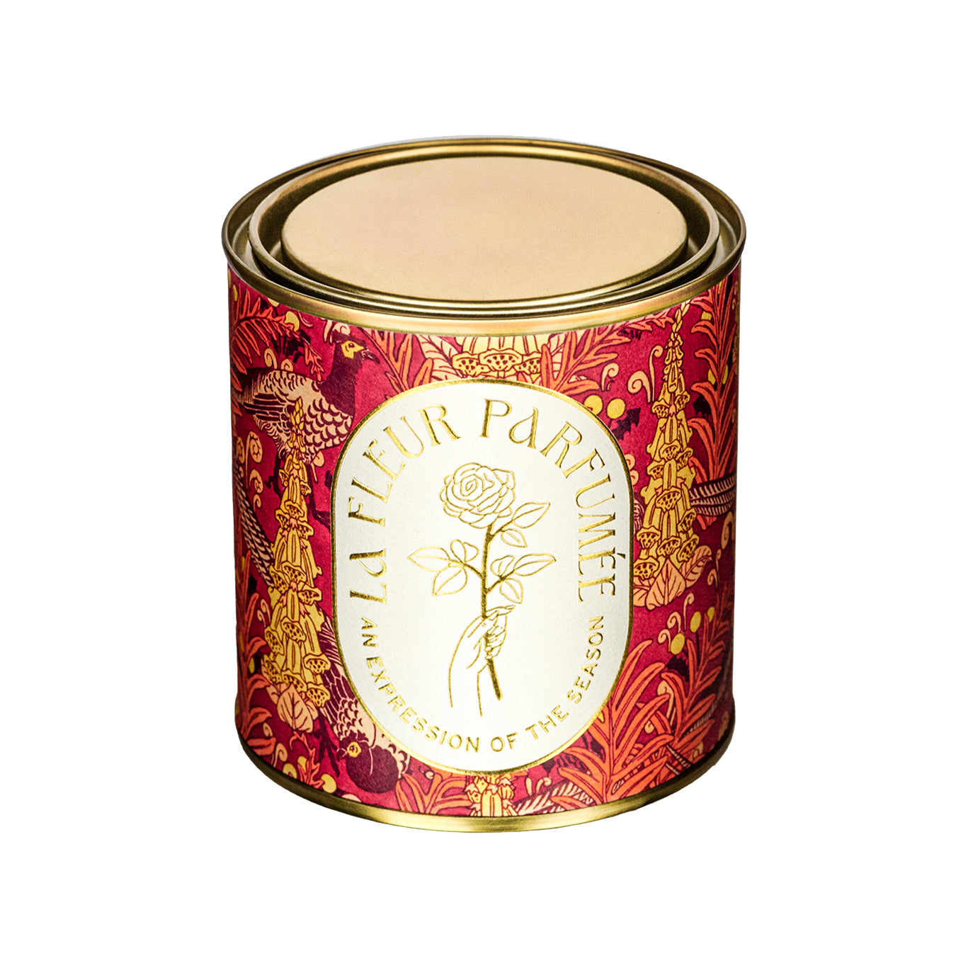 A luxury scented candle with a bold seasonal, fall, thanksgiving themed pattern, with a crisp white label and gold writing that reads LA FLEUR PARFUMÉE: An Expression of the Season, and an illustration of a hand holding an elegant rose by the stem.