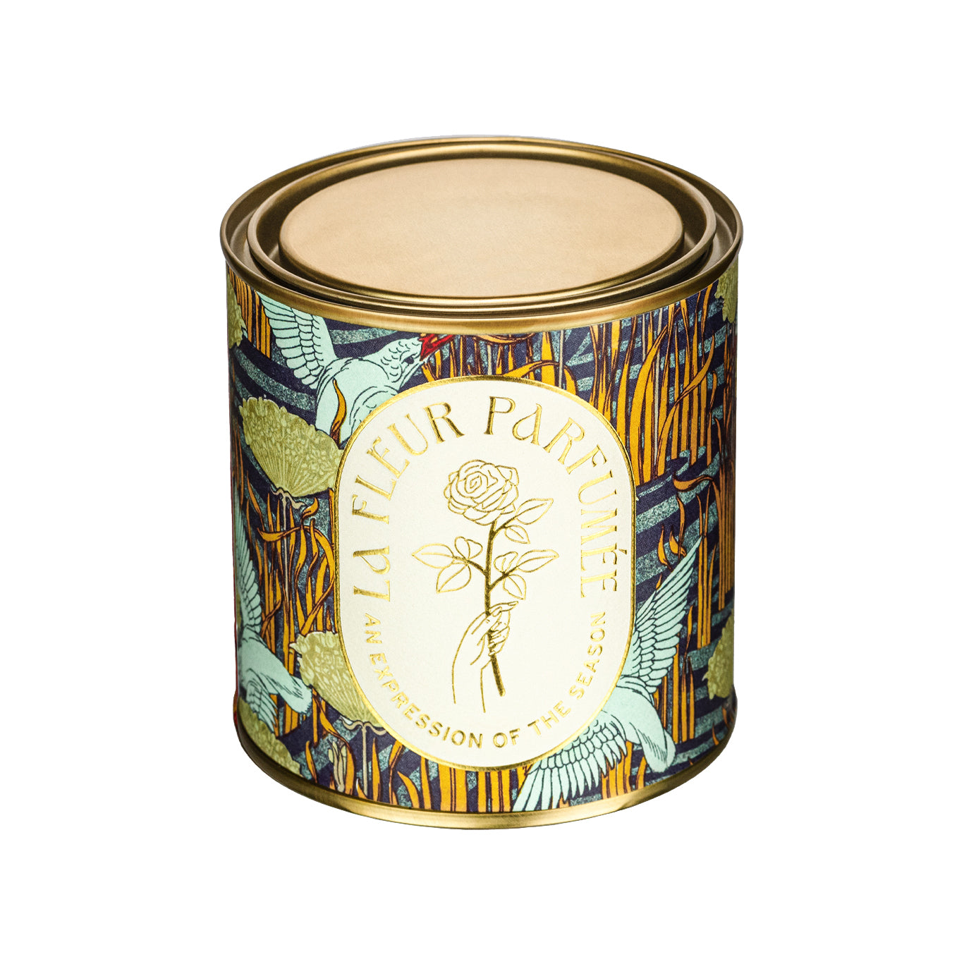 A luxury scented candle with a bold seasonal, fall, nature inspired pattern, of birds by the river with a crisp white label and gold writing that reads LA FLEUR PARFUMÉE: An Expression of the Season, and an illustration of a hand holding an elegant rose by the stem.