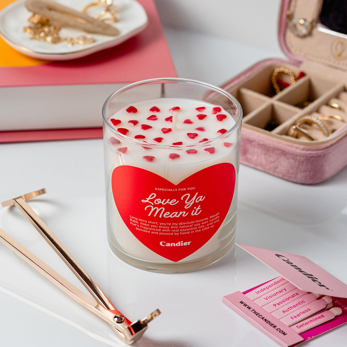 A cute scented candle with heart shaped sprinkles and a heart shaped label that reads Love Ya Mean It by Candier®, with cute jewelry, matches and candel trimmer