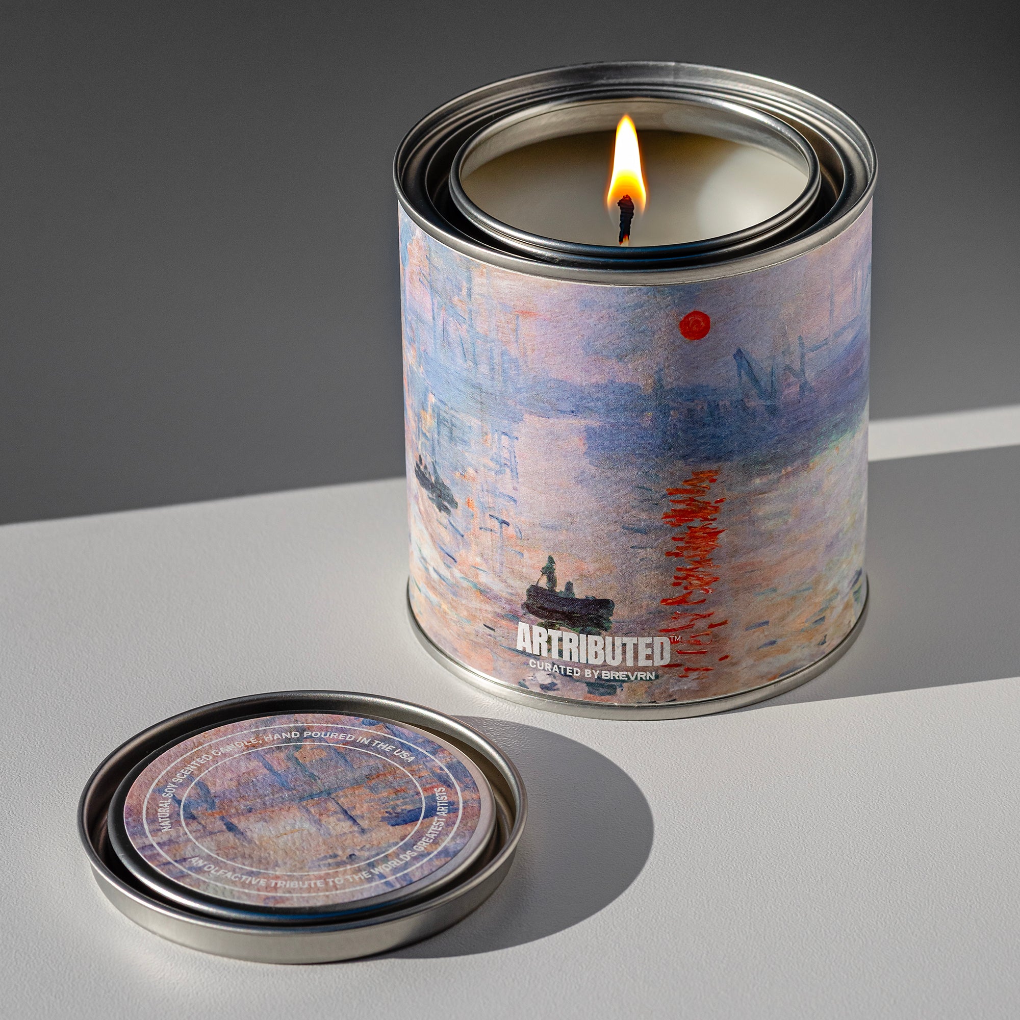 Lit fine art candle inspired by and wrapped in Monet famous painting  Impression, Sunrise. 