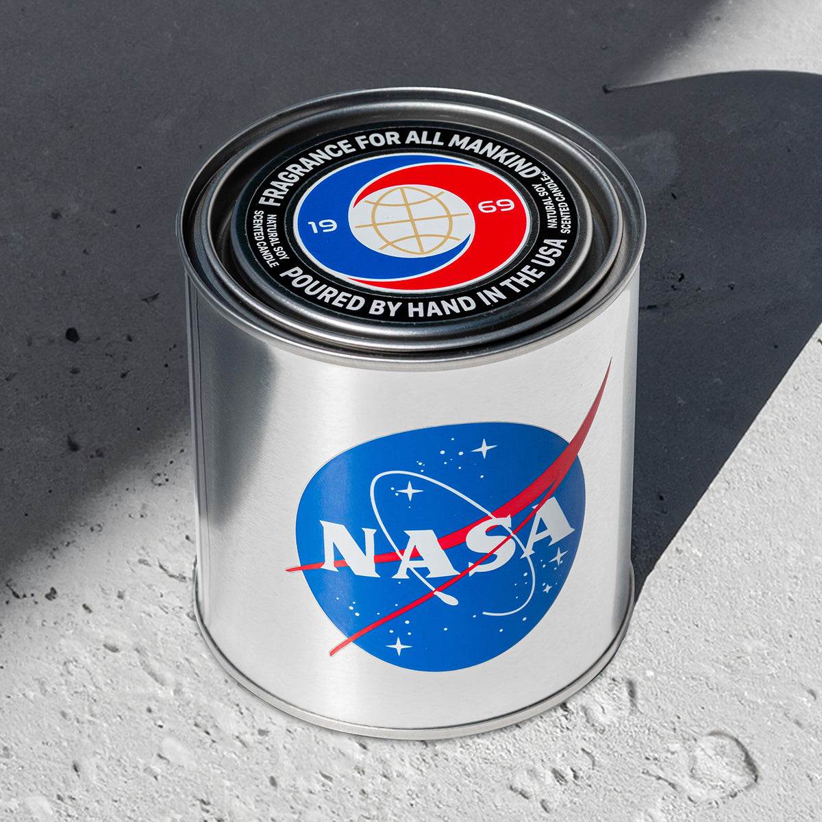 A close-up of the NASA 1969 candle lid, showcasing the “Fragrance for All Mankind” design and high-quality craftsmanship. Hand-poured in the USA.