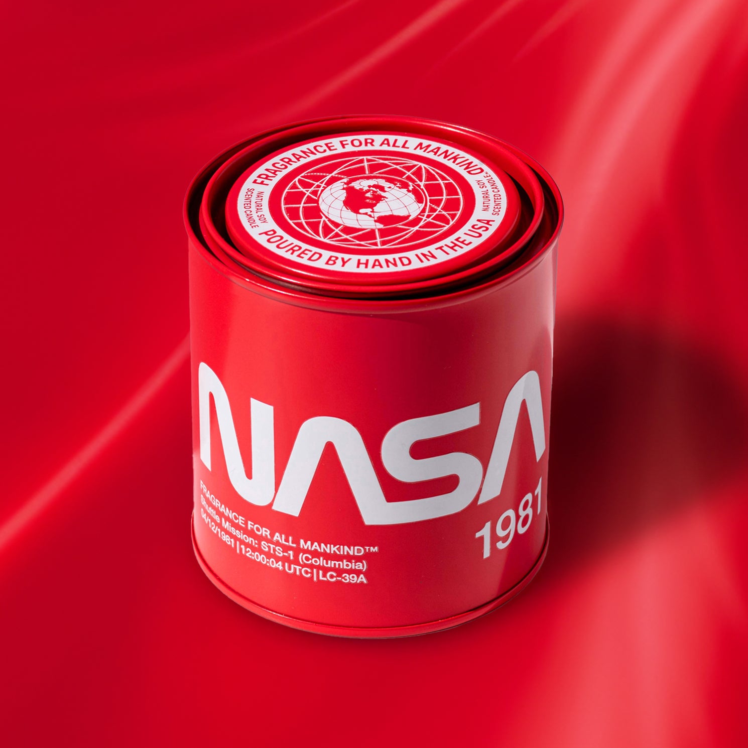 Close-up of the NASA 1981 candle on a red background – Featuring premium soy wax, a bold fragrance with amber, oud, and tobacco leaf, and innovative safety feature.