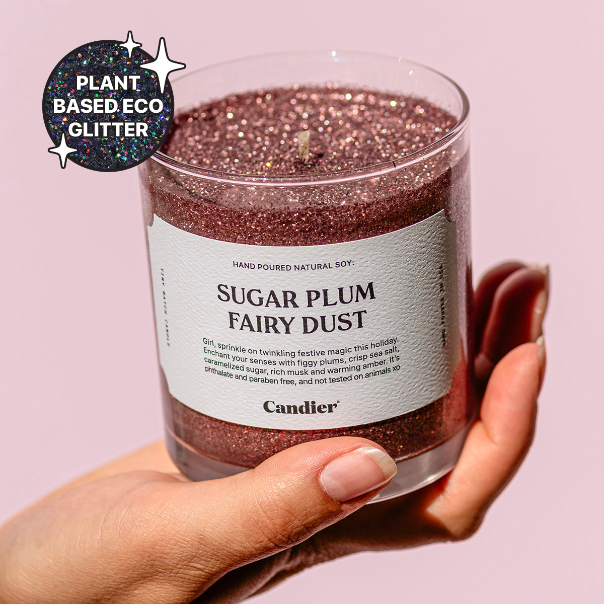 A cute festive Christmas themed pink candle with a label that reads Sugar Plum Fairy Dust t by Candier and a badge that says Plant Based Eco Glitter