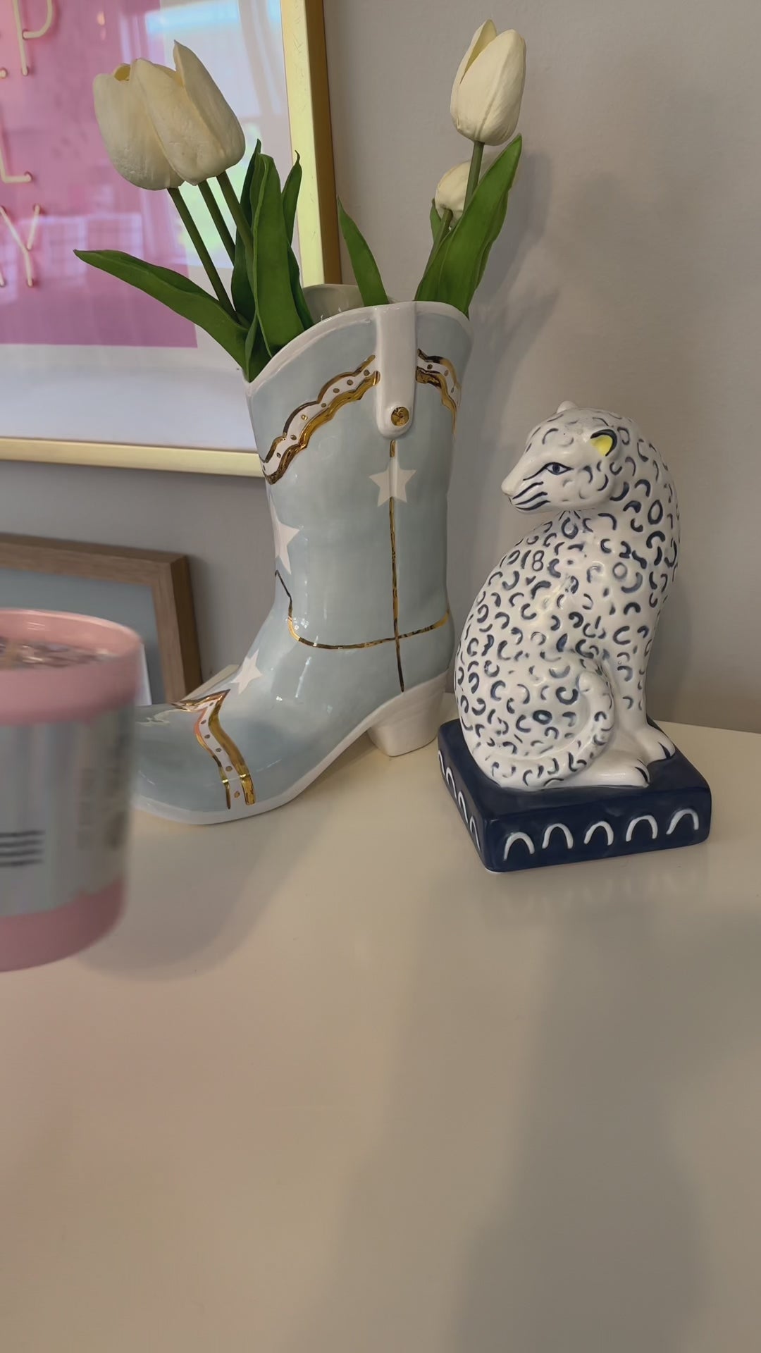 video of a pink candle with plant based glitter and a shiny holographic label that reads Let's Go Girls, being lit by a cute pink match, with cute cowgirl decor behind it